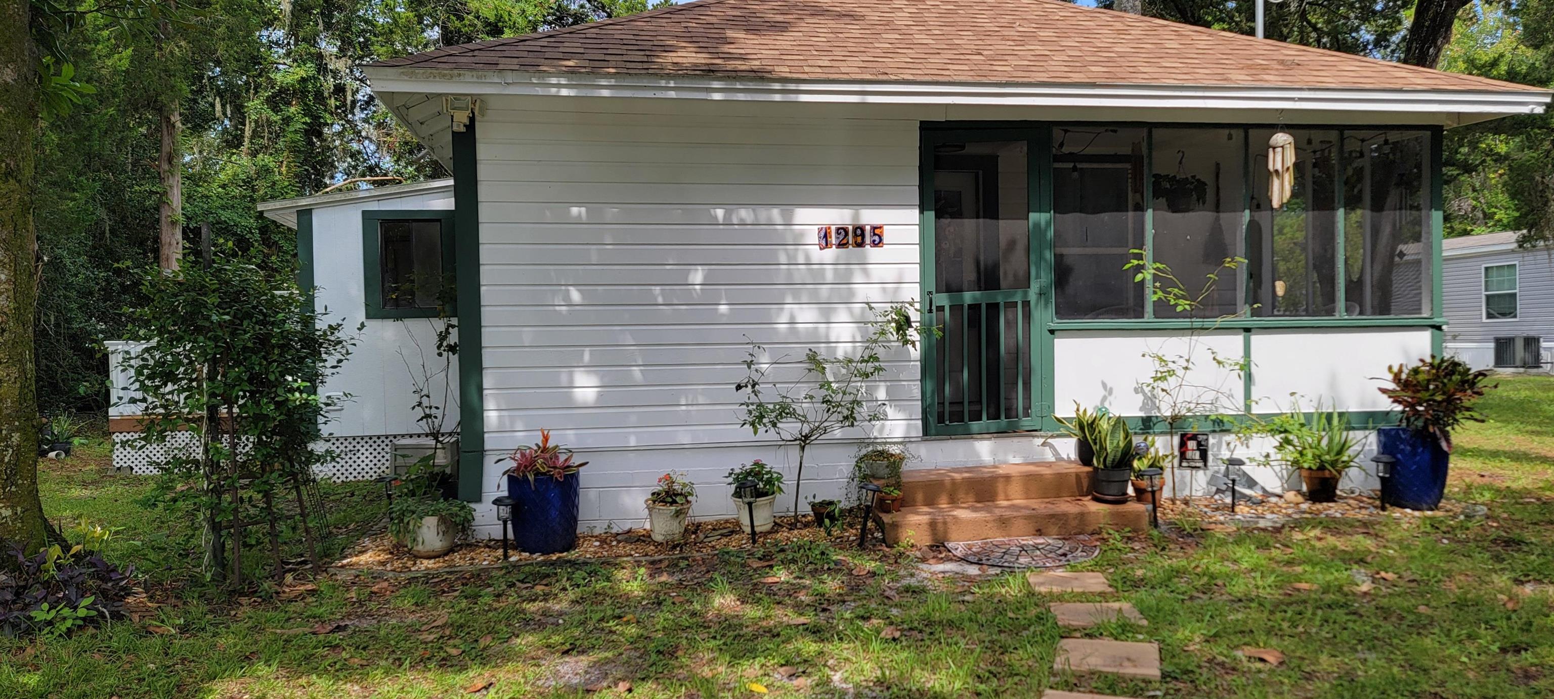 1295 Woodlawn Road St. Augustine, FL 32084 - Photo 1 of 19 a front view of a house with garden