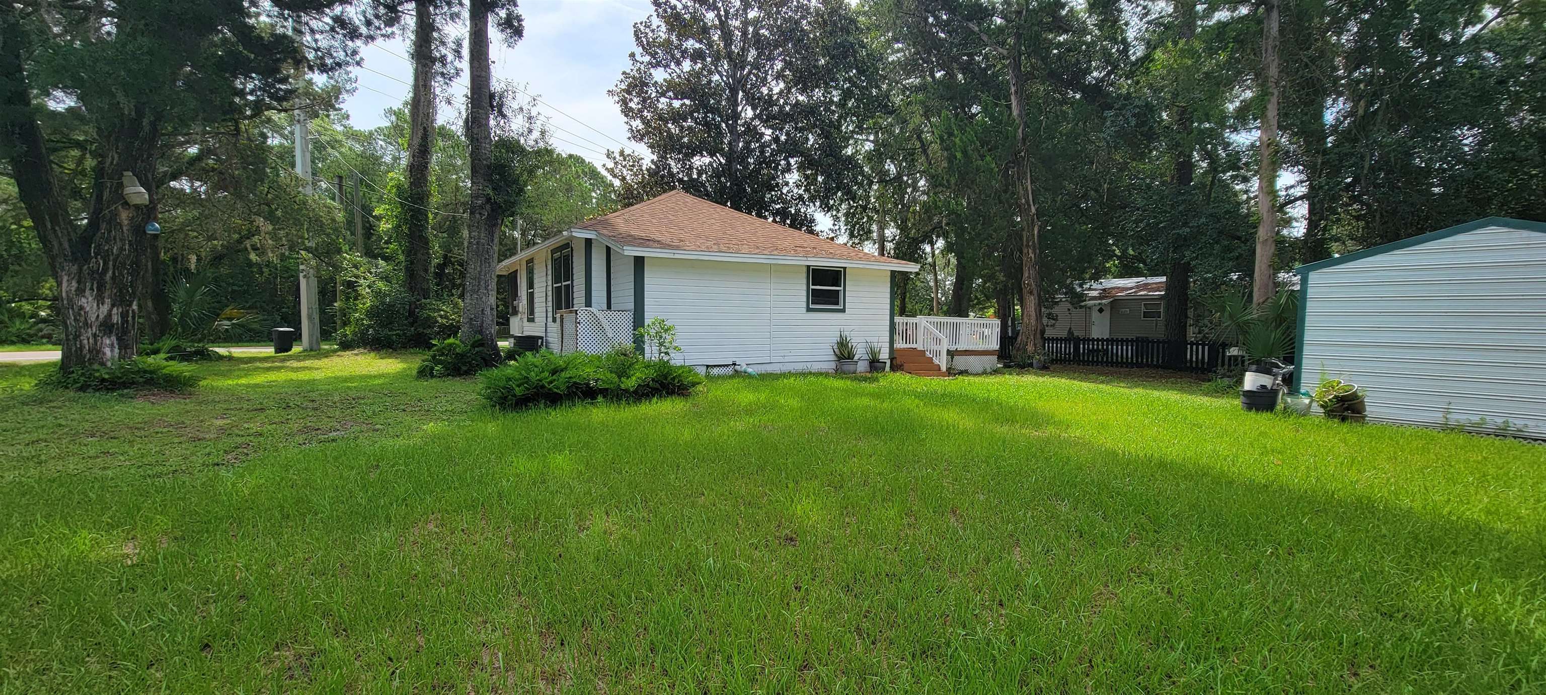 1295 Woodlawn Road St. Augustine, FL 32084 - Photo 17 of 19 a front view of house with a garden and trees