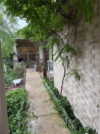 a backyard of a house with table and chairs under an umbrella