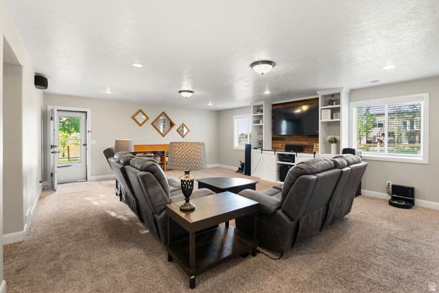 2485 South 1100th Street West Logan, UT 84321 - Photo 27 of 53 Spacious entertainment area featuring neutral-toned carpeting, recessed lighting, and a built-in media center with shelving