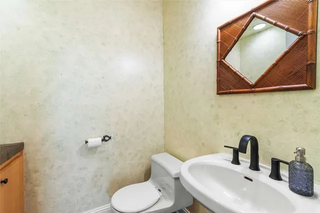 a bathroom with a toilet sink and mirror