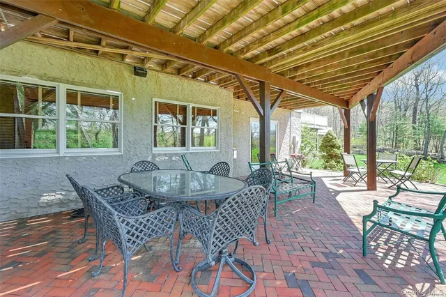 a view of a white house with a big yard and large trees