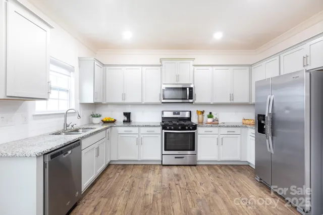 a kitchen with stainless steel appliances granite countertop a refrigerator stove top oven and sink