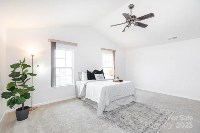 a bedroom with a bed a dresser and a window