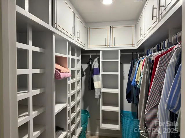 a view of walk in closet with clothes and shoes