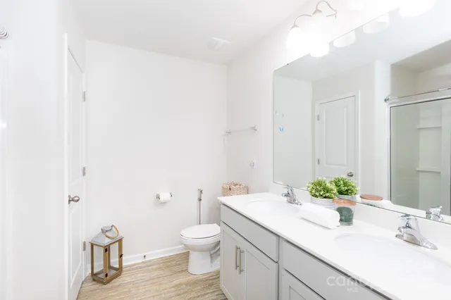 a bathroom with a granite countertop sink a toilet and a mirror