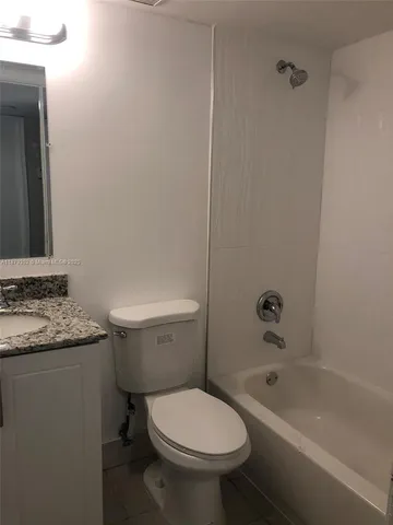 a bathroom with a granite countertop toilet a sink and bathtub