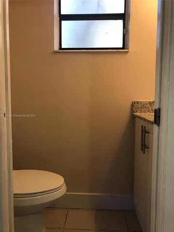 a bathroom with a toilet and a picture on the wall