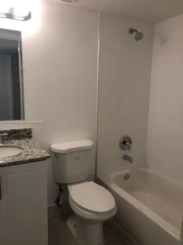 a bathroom with a granite countertop toilet a sink and bathtub