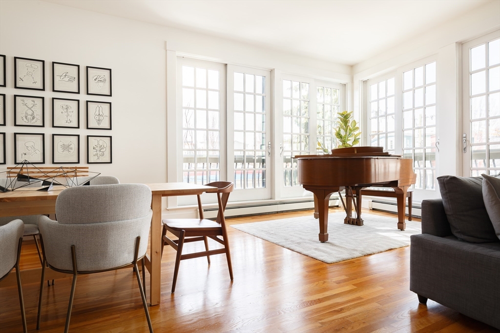 a living room with furniture a large window and wooden floor