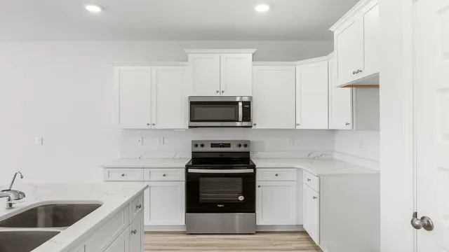 a kitchen with white cabinets and stainless steel appliances