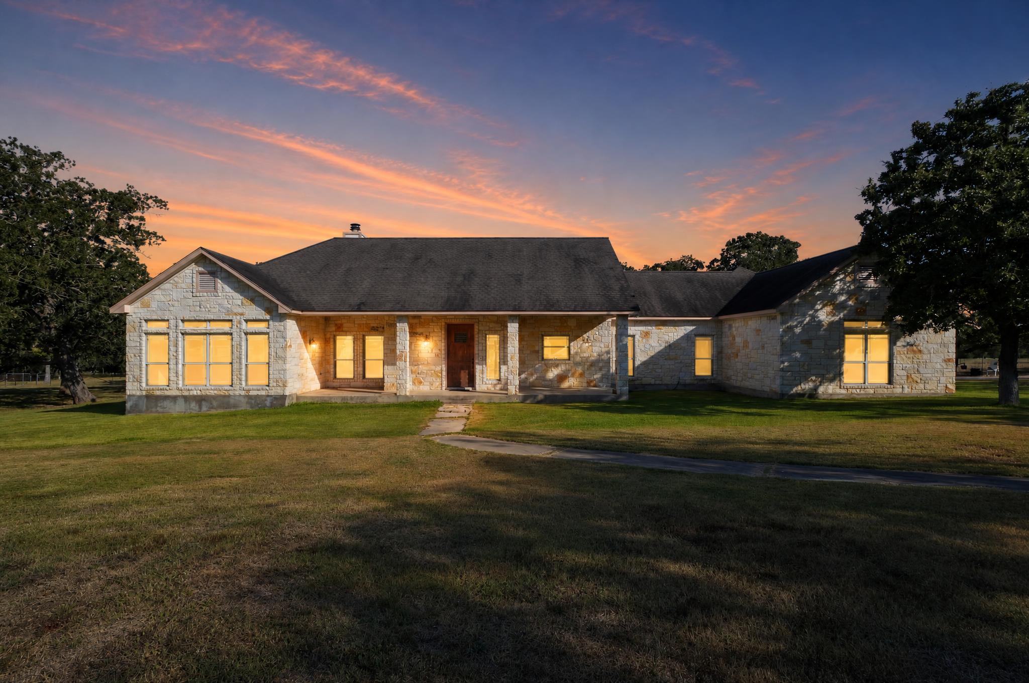 986 High Grove Road Cedar Creek, TX 78612 - Photo 1 of 30 Natural stone masonry and a classic covered porch define this sprawling ranch-style facade.