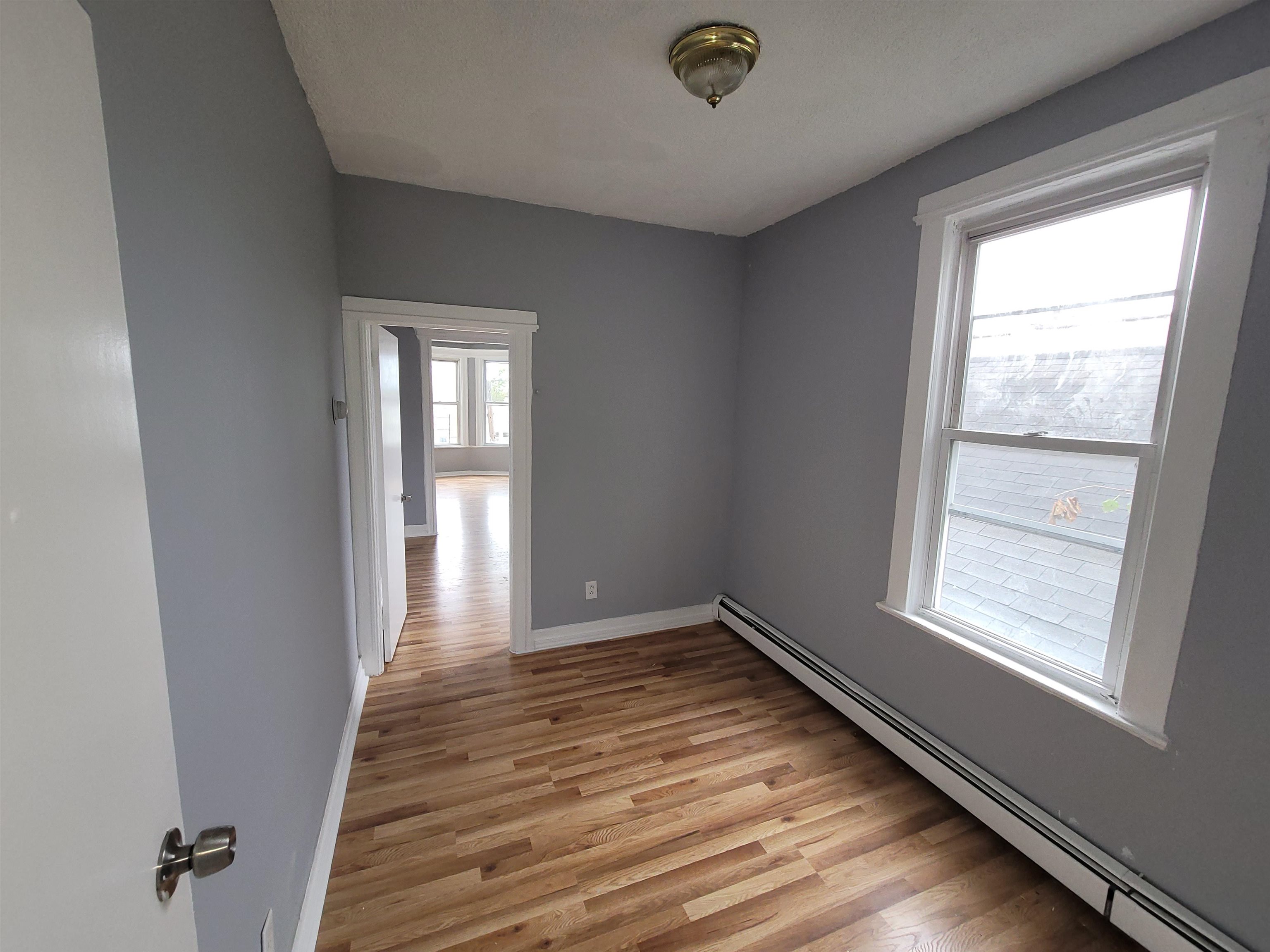 1700 John F. Kennedy Boulevard, Unit 3L Jersey City, NJ 07305 - Photo 11 of 13 an empty room with wooden floor and windows