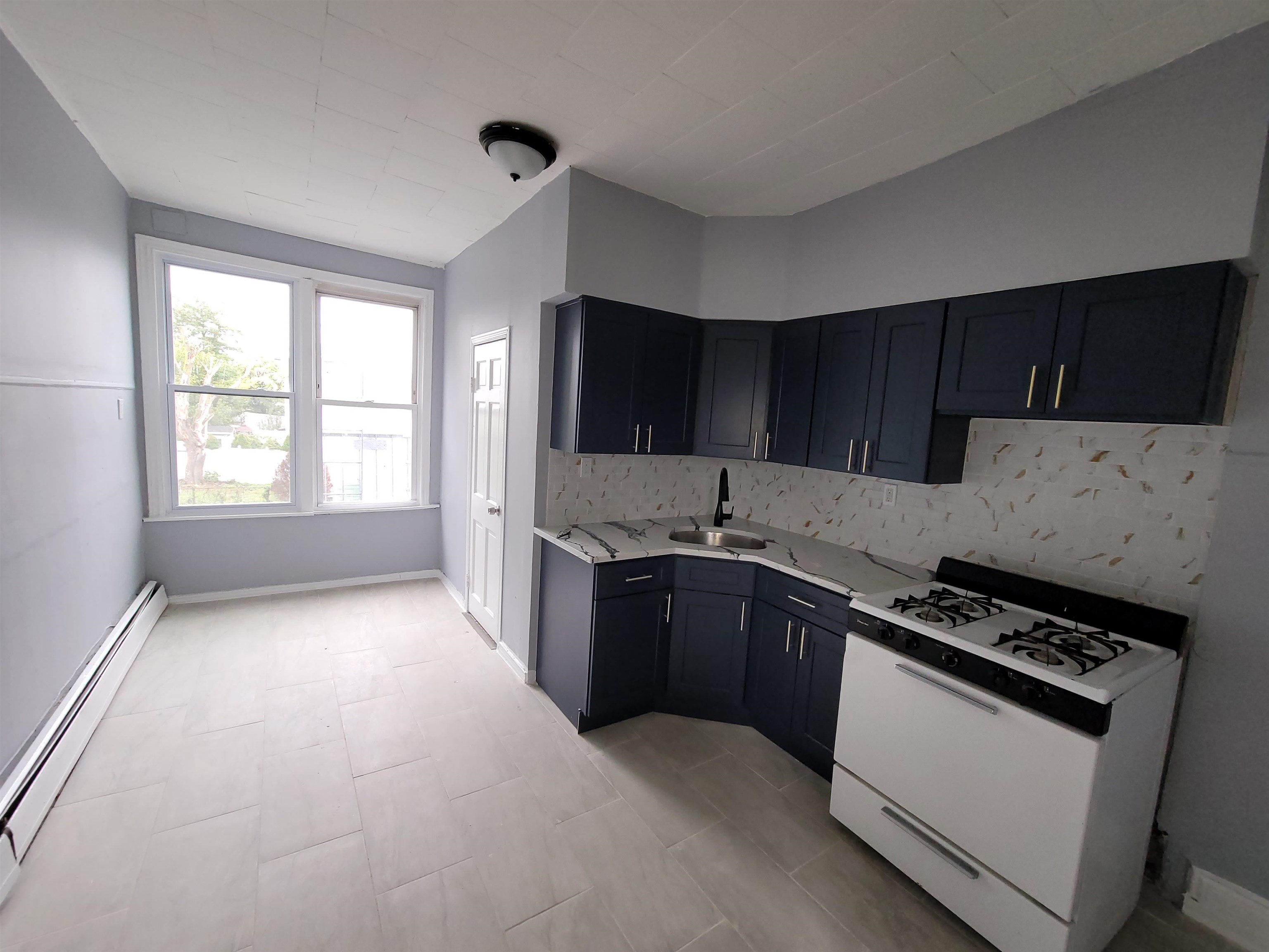 1700 John F. Kennedy Boulevard, Unit 3L Jersey City, NJ 07305 - Photo 2 of 13 a kitchen with granite countertop a stove a sink and a refrigerator