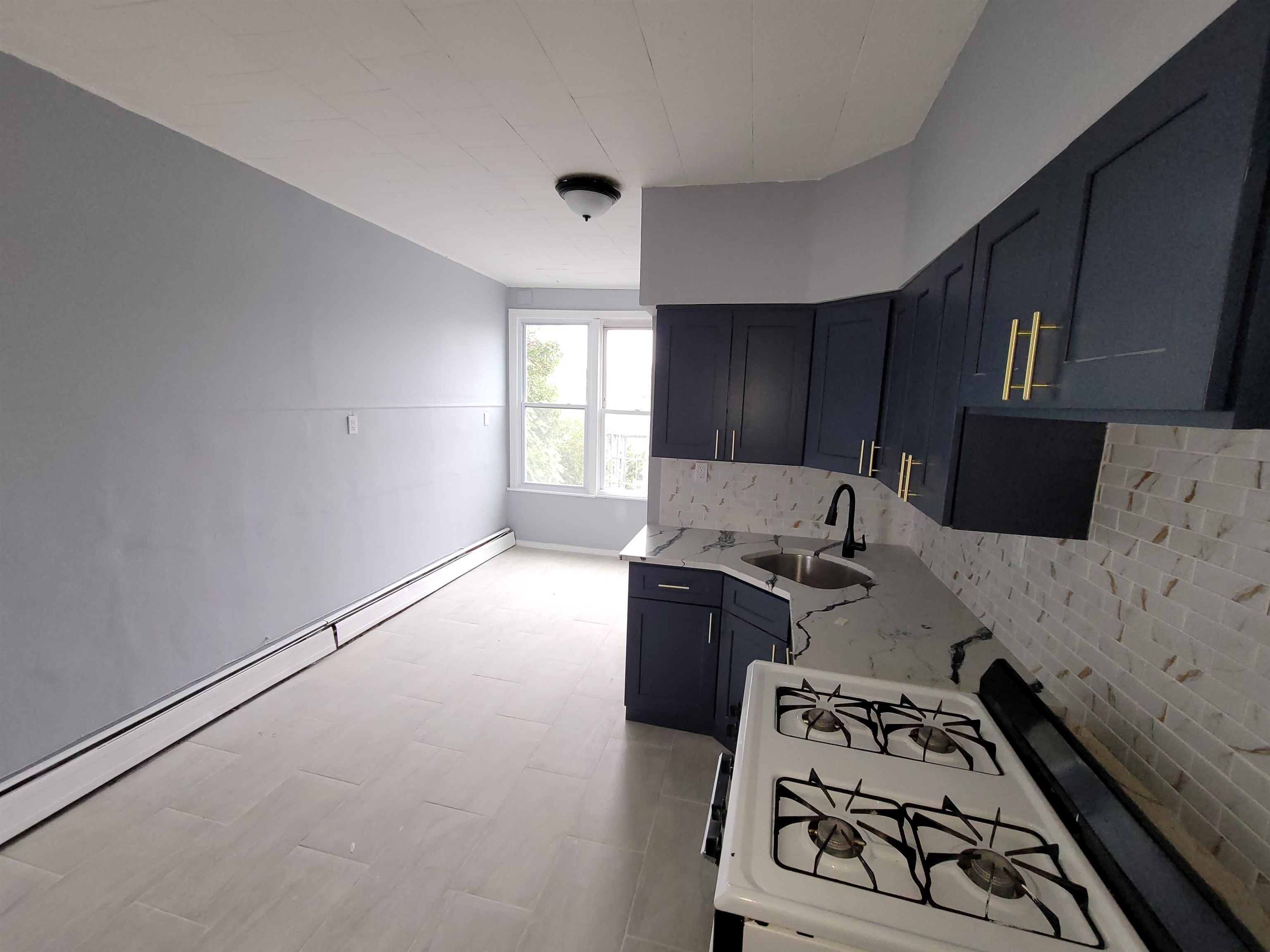 1700 John F. Kennedy Boulevard, Unit 3L Jersey City, NJ 07305 - Photo 4 of 13 a kitchen with a stove and a refrigerator