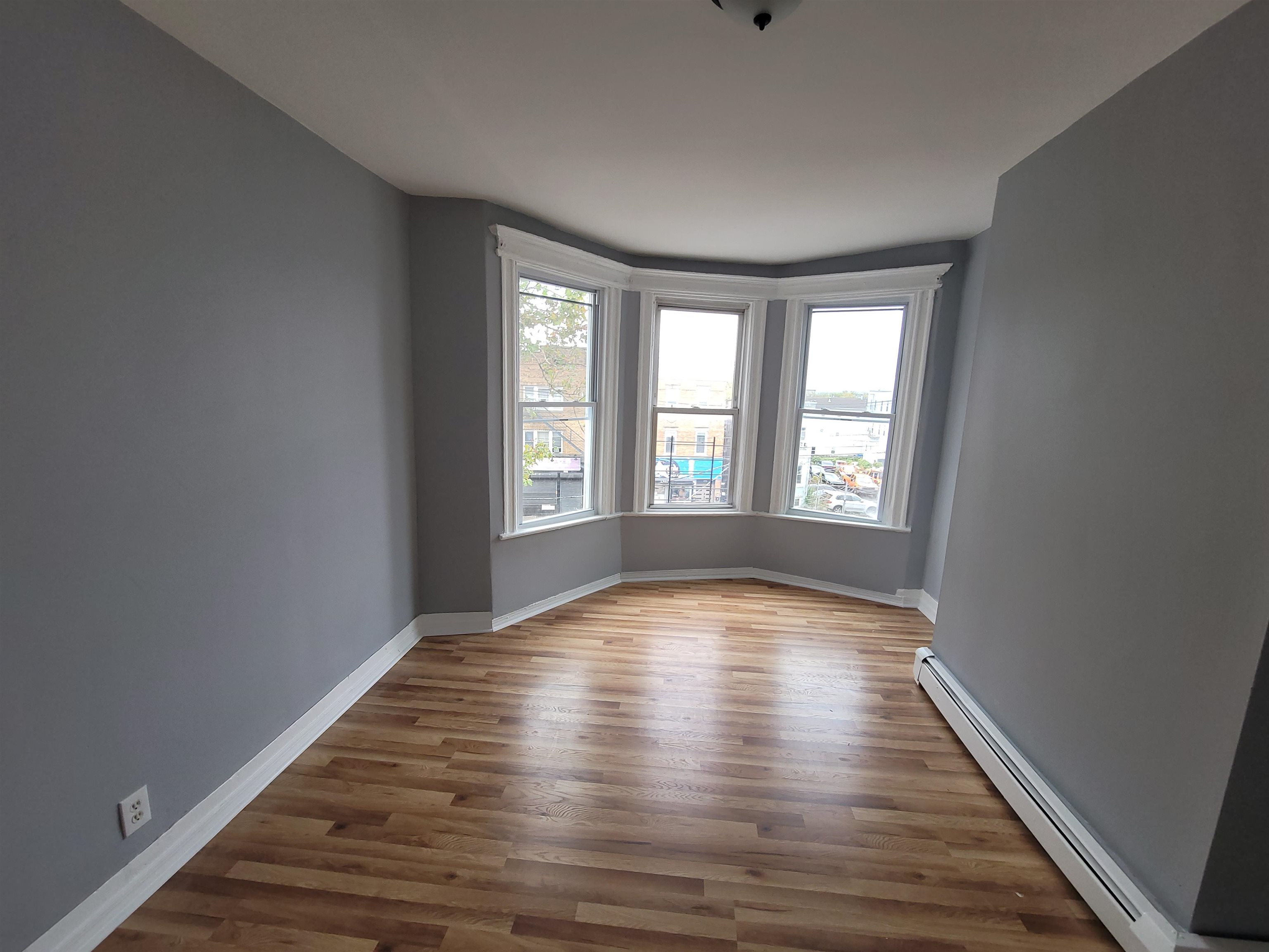 1700 John F. Kennedy Boulevard, Unit 3L Jersey City, NJ 07305 - Photo 7 of 13 a view of an empty room with wooden floor and a window