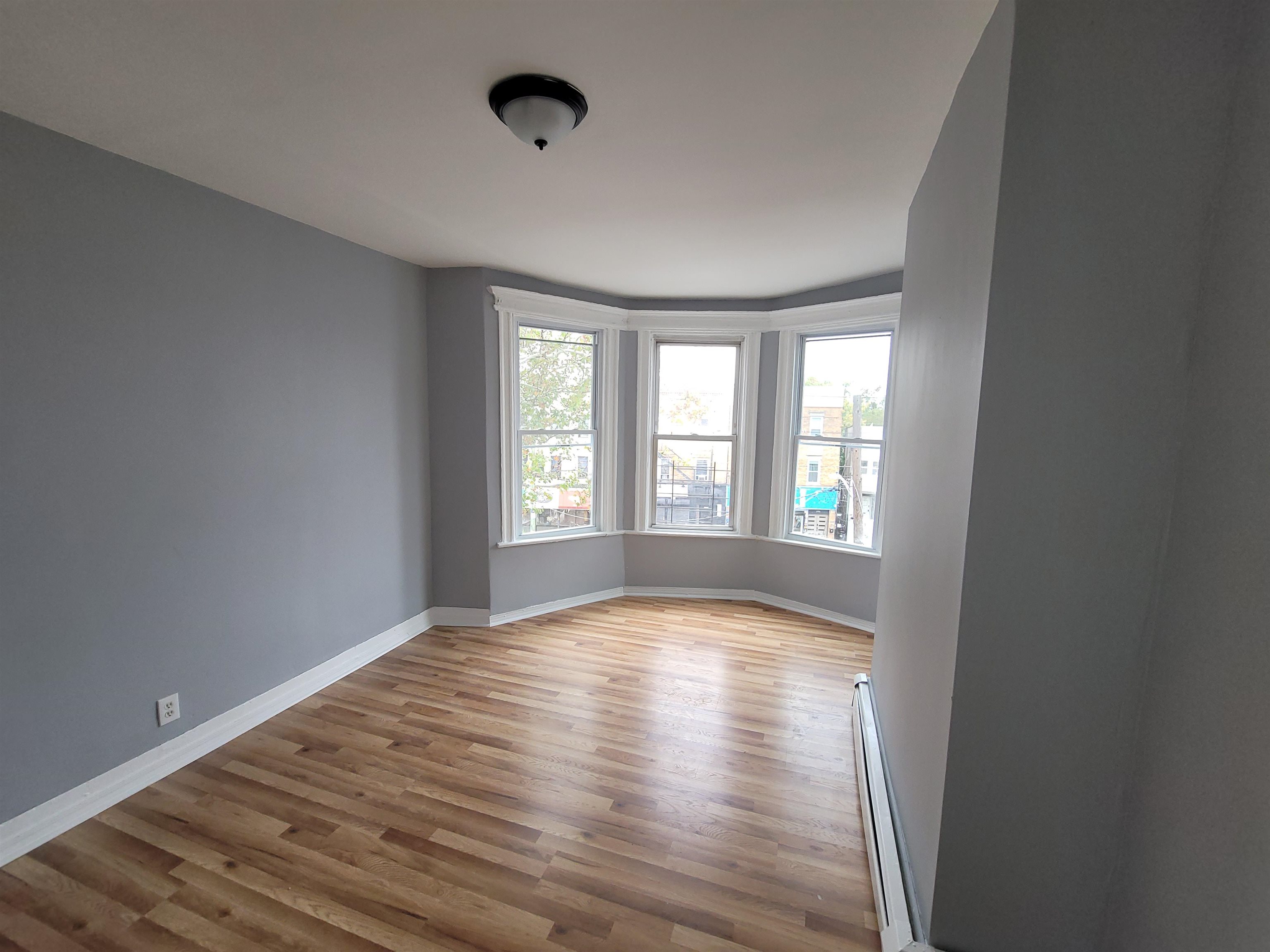 1700 John F. Kennedy Boulevard, Unit 3L Jersey City, NJ 07305 - Photo 8 of 13 a view of an empty room with wooden floor and a window