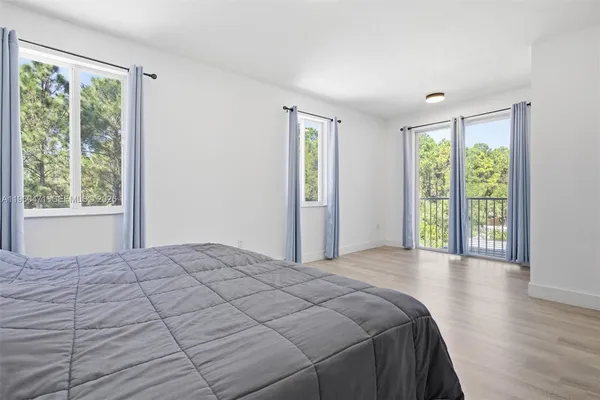 a bedroom with a bed and a large window