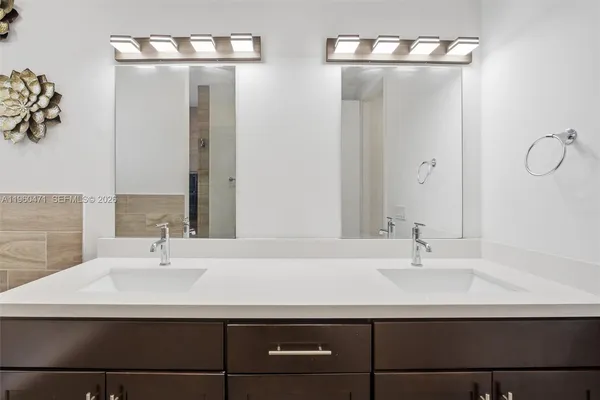 a bathroom with double vanity sinks and a mirror