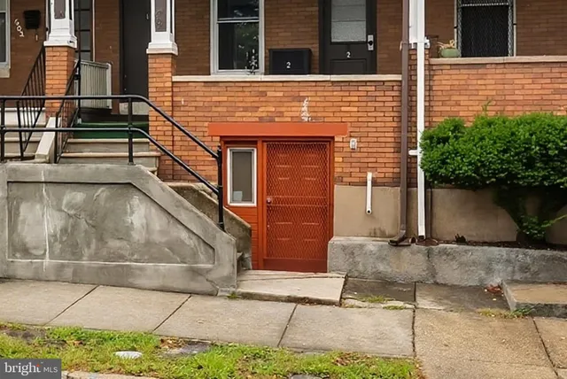 a brick building with a bench in front of door