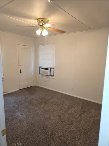 an empty room with a fan and a chandelier fan