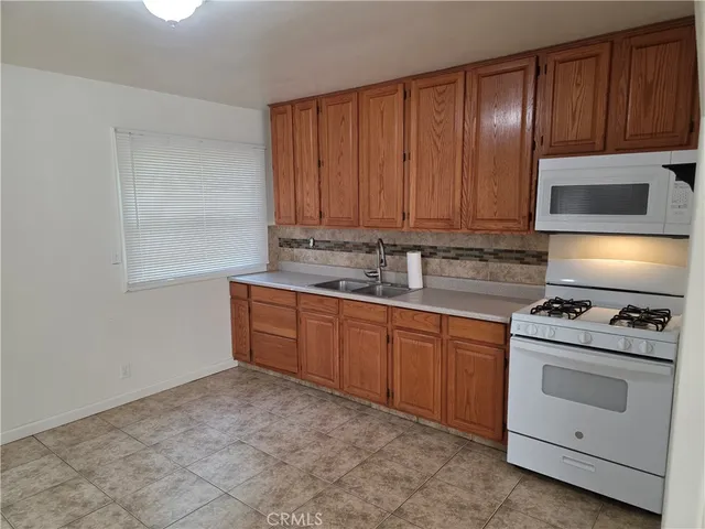 a kitchen with granite countertop wooden cabinets and white appliances