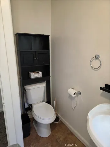 a white toilet sitting next to a bathroom sink and vanity