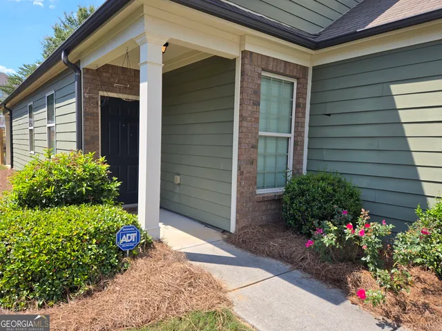 a view of a house that has a flower garden