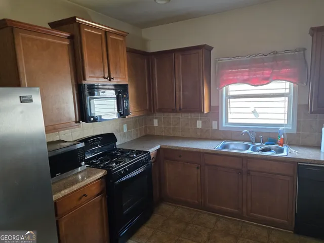 a kitchen with stainless steel appliances a sink stove and cabinets