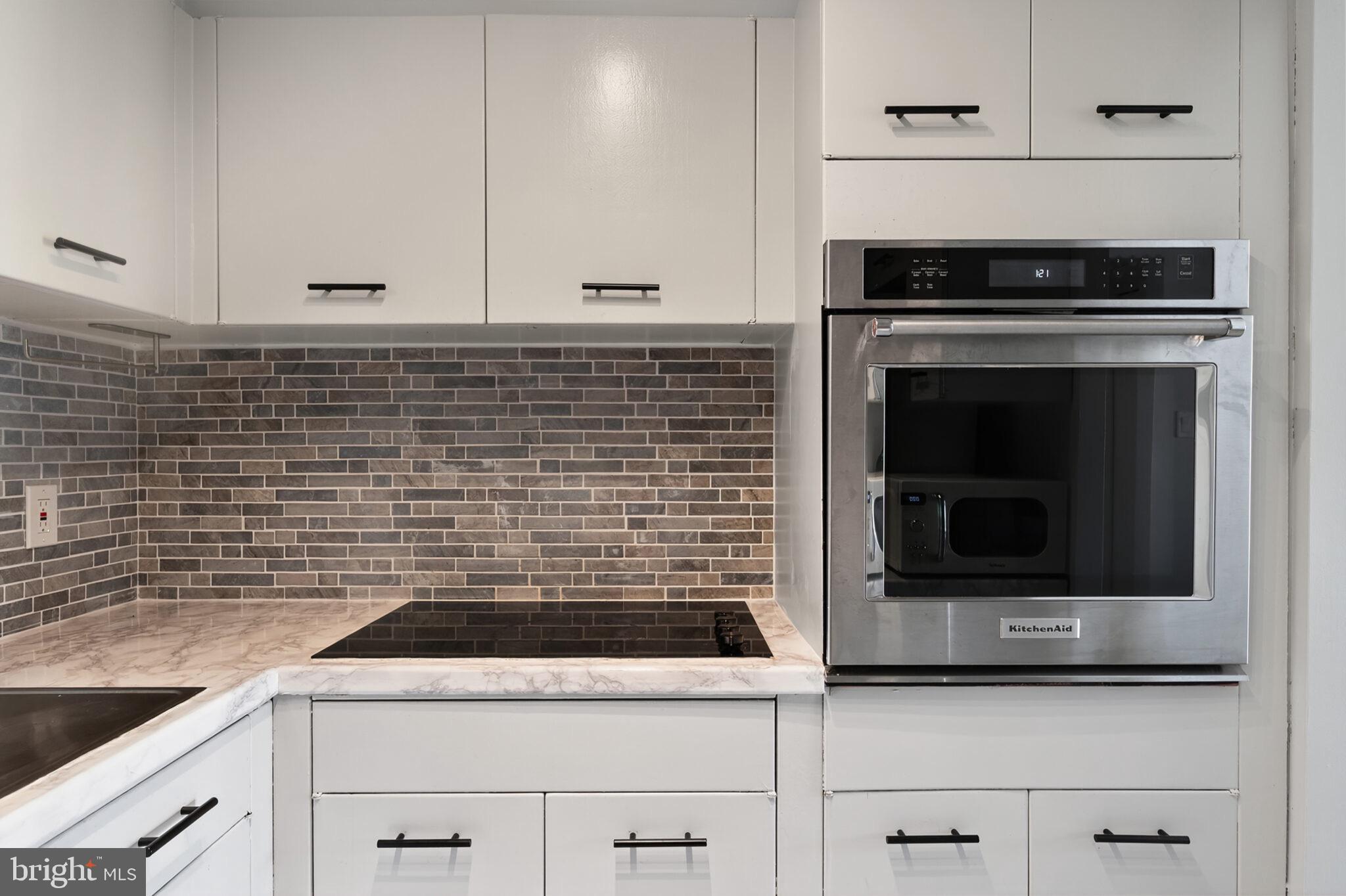 560 N Street Southwest, Unit N503 Washington, DC 20024 - Photo 14 of 35 a kitchen with granite countertop white cabinets and stainless steel appliances