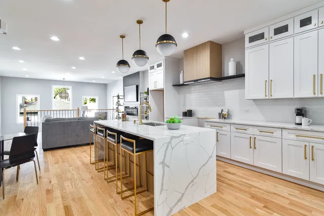 a kitchen with stainless steel appliances granite countertop wooden cabinets a stove a sink and a refrigerator