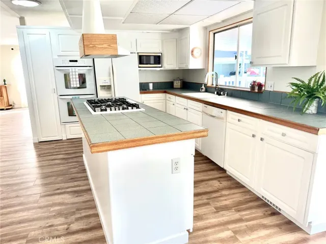 a large kitchen with stainless steel appliances kitchen island granite countertop a large counter top and a view of living room