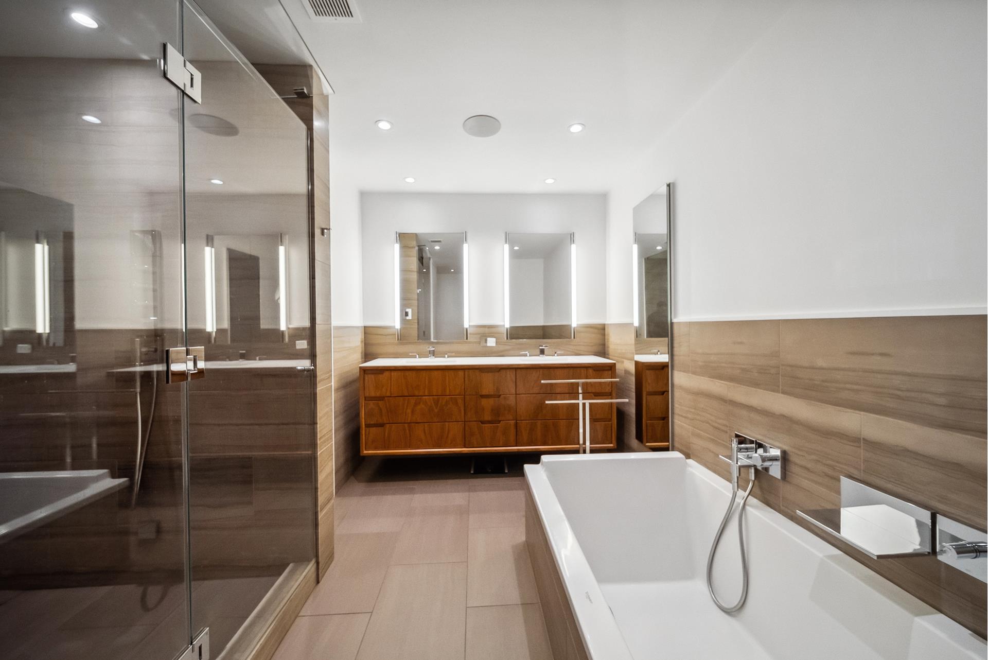 240 Centre Street, Unit 5B Manhattan, NY 10013 - Photo 20 of 37 a bathroom with a tub a sink and mirrors