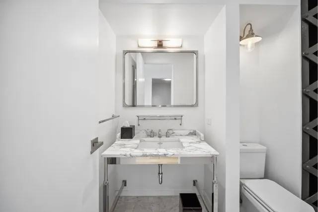 a bedroom with a bed and a lamp on the dresser