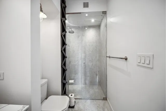 a bathroom with a granite countertop sink toilet and shower