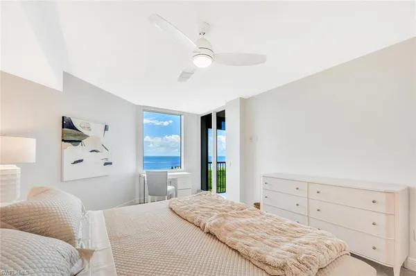 a bedroom with a large bed and ceiling fan