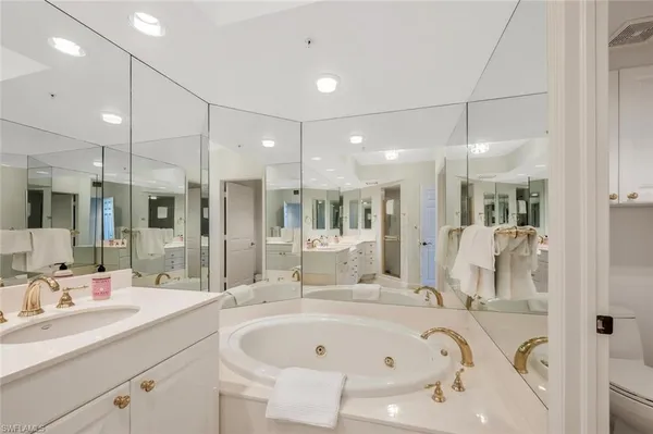 a bathroom with a tub sink shower and mirror