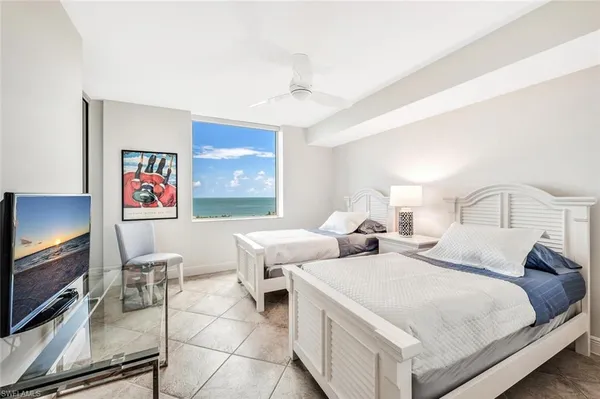 a bedroom with two beds and a flat screen tv