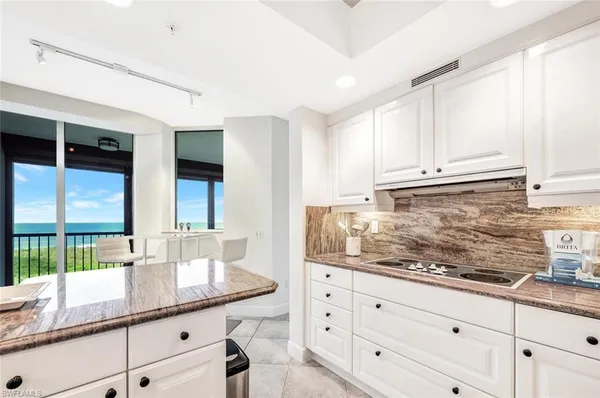 a kitchen with granite countertop white cabinets and white appliances