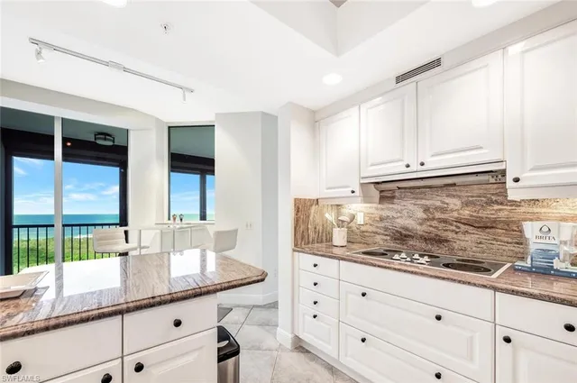 a kitchen with granite countertop white cabinets and white appliances