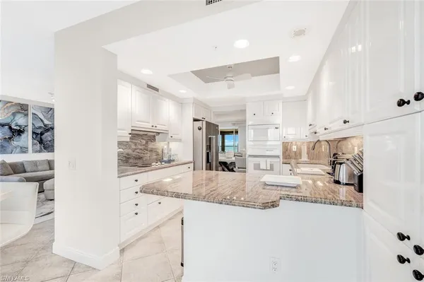 a large white kitchen with cabinets and a sink