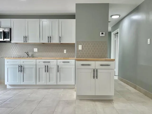 a view of cabinets a sink and a stove in a kitchen