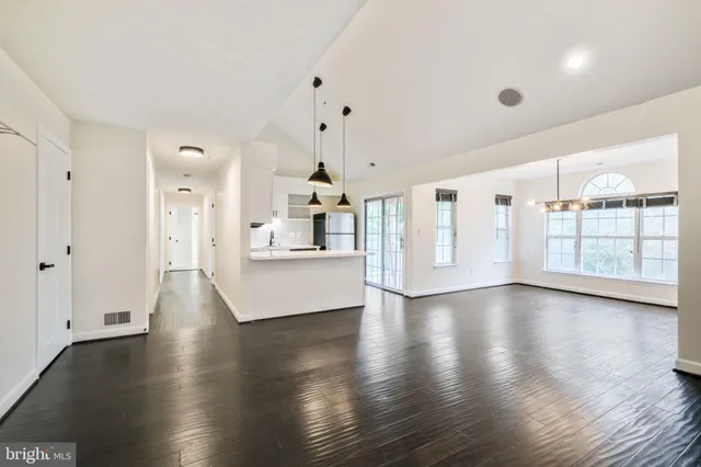 a view of a big room with wooden floor and windows
