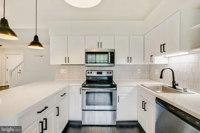 a kitchen with a sink and a stove top oven
