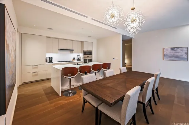 a open dining room with furniture and chandelier