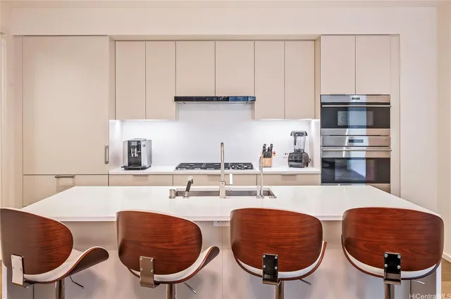 a kitchen with stainless steel appliances a sink a stove a microwave a sink and cabinets