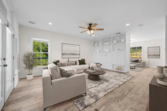 a living room with furniture a flat screen tv and kitchen view