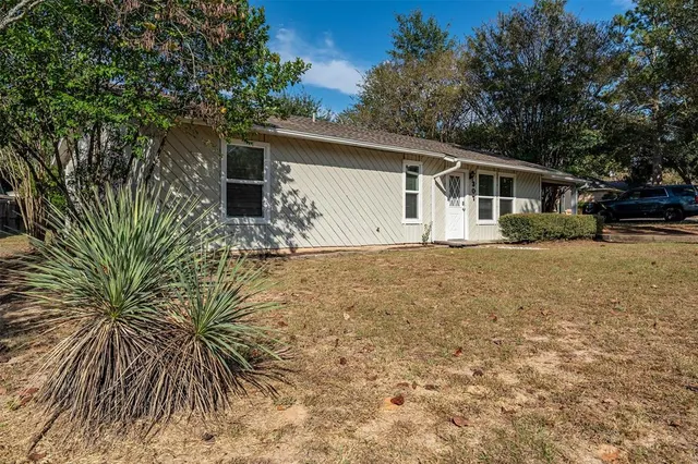 a front view of house with yard and trees around