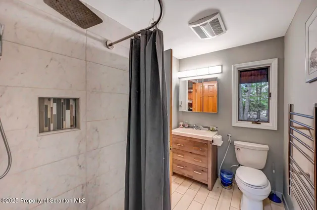 a view of an empty room with wooden floor and stairs