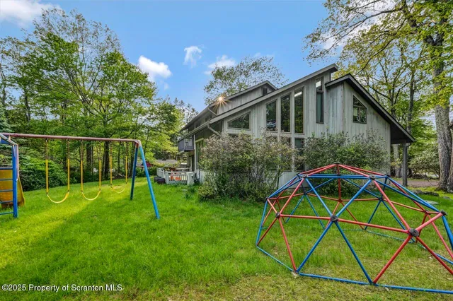 a view of a house with a big yard and large trees